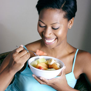 Woman enjoying a bowl of fresh fruits.