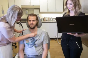 Doctor examining patient with stethoscope