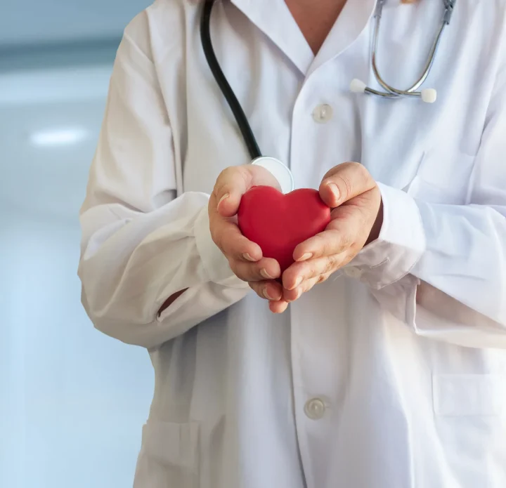 Doctor holding a red heart symbolizing care and compassion