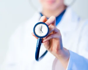 Doctor holding stethoscope shaped like a clock