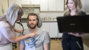 Doctor examining patient with stethoscope