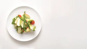 plate of mixed green salad with vegetables forming a helix symbol