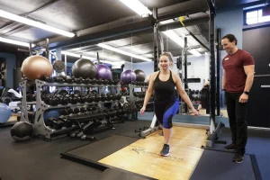 Personal trainer guiding a client through an exercise in the Preventous gym