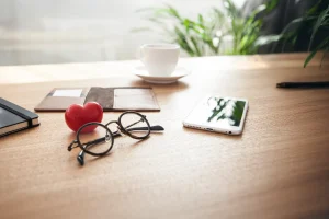 Glasses on a desk with a red heart, representing medical expenses and tax savings
